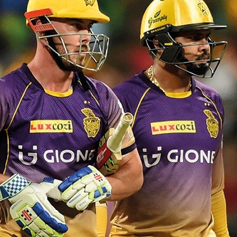 A photograph of two Kolkata Knight Rider players in helmet carrying a cricket bat